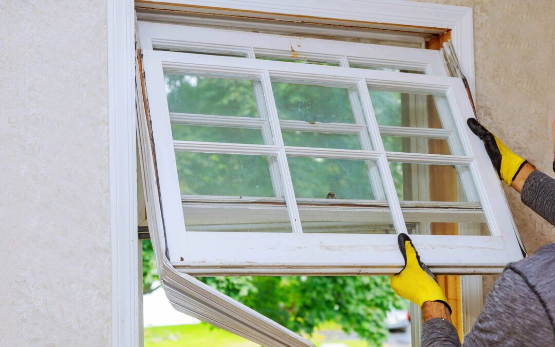 Professional installer removing a damaged double-hung window frame during a home renovation project, preparing for window replacement near me in Richmond, VA.